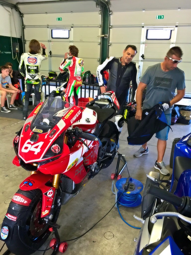 Σε πρώτο πλάνο ο Γιάννης Μπούστας με την R1 και πίσω στο γκαράζ της VR|46 o Bulega και ο Bezzechi μιλούν με τον Luca