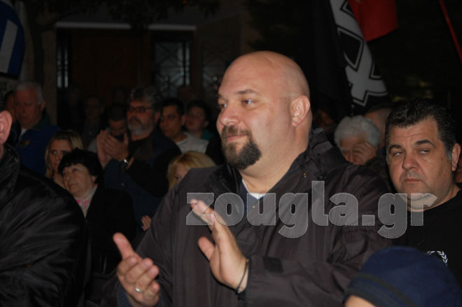 Ο Ηλίας Παναγιώταρος. Πίσω του διακρίνεται ο προφυλακισμένος κατηγορούμενος για τη δολοφονία του Παύλου Φύσσα, Γιώργος Ρουπακιάς