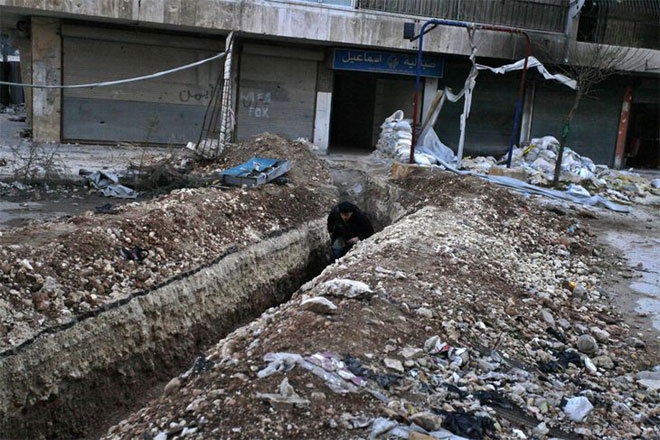 Χαλέπι, 17 Δεκεμβρίου. Ένα μέλος του εξτρεμιστικού Μετώπου Αλ Νόρσα διασχίζει μία τάφρο που οδηγεί στην περιοχή Μπουστάν Αλ-Κασρ