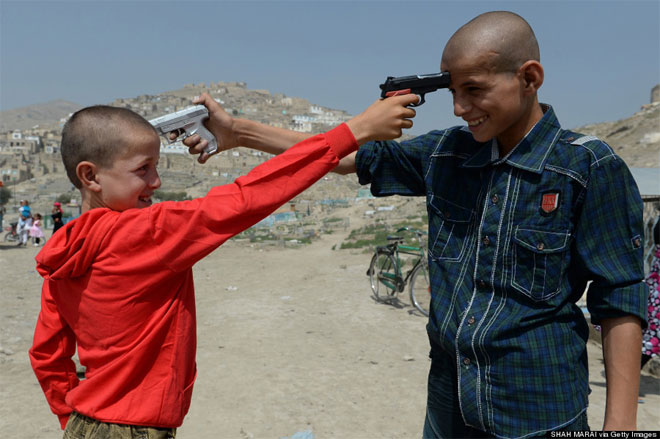 8 Αυγούστου. Δύο παιδιά στο Αφγανιστάν έχουν για παιχνίδι αληθινά όπλα. Παίζουν σημαδεύοντας ο ένας τον άλλο. Σημειωτέον ότι κατά το πρώτο μισό του 2013, οι θάνατοι πολιτών από εκπυρσοκροτήσεις όπλων σκαρφάλωσαν στο 23%.