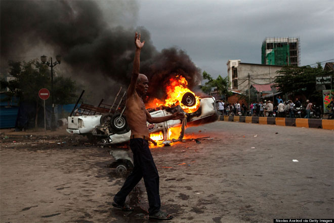 28 Ιουλίου. Ένας άνδρας από την Καμπότζη πανηγυρίζει την καταστροφή πολλών περιπολικών αφότου οι διαδηλωτές διέκοψαν τις εκλογές. Οι ψηφοφόροι της Καμπότζης άρπαξαν και κράτησαν επί ώρες έναν υπάλληλο της Εθνικής Επιτροπής Εκλογών, η οποία είχε προσπαθήσει να εισάγει διακρίσεις κατά κάποιων ψηφοφόρων.