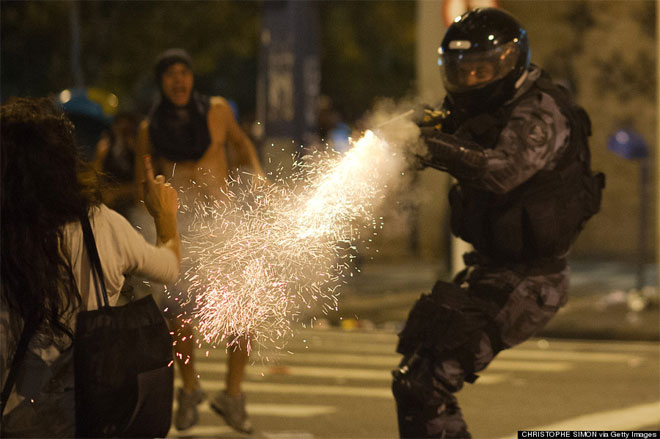 19 Ιουνίου. Μία γυναίκα υψώνει το δάχτυλό της στον αστυνομικό που την πυροβολεί με δακρυγόνα. Πρόκειται για μία από τις πολλές ημέρες μαζικότατων διαδηλώσεων στη Βραζιλία κατά της επερχόμενης αύξησης των εισιτηρίων στα μέσα μαζικής μεταφοράς.