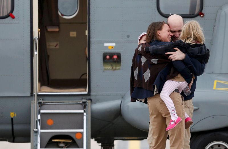 Ο Ενέν αγκαλιάζει τη γυναίκα και τα δυο του παιδιά