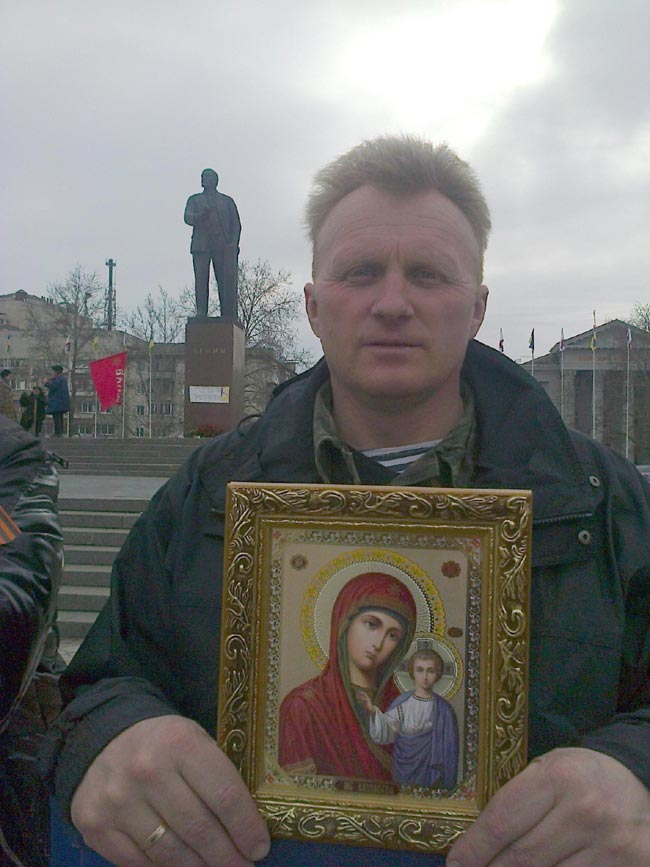 Φιλορώσος κρατά την εικόνα της Παναγίας μπροστά από τα Άγαλμα του Λένιν στη Συμφερόπολη της Κριμαίας - της ανταποκρίτριας της RAI  Lucia Goracci