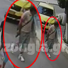 O Mαζιώτης στην οδό Αδριανού κρατώντας όπλο