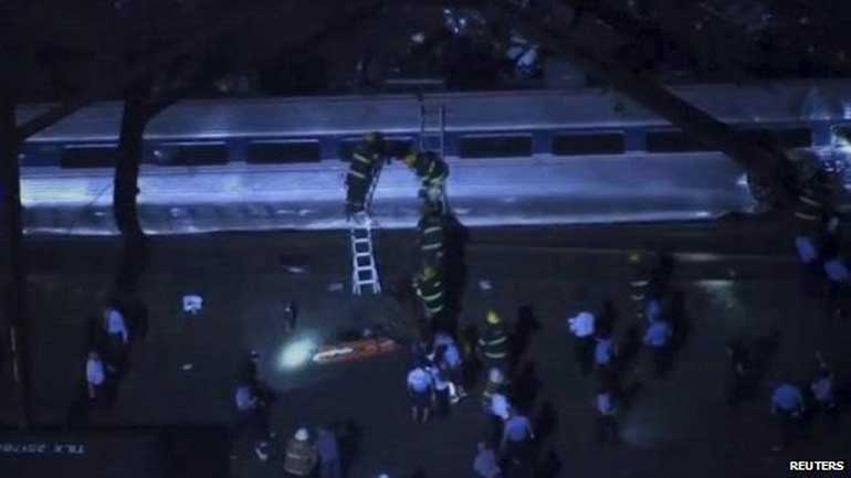 Διασώστες χρησιμοποιούν σκάλες για να μπουν στα βαγόνια