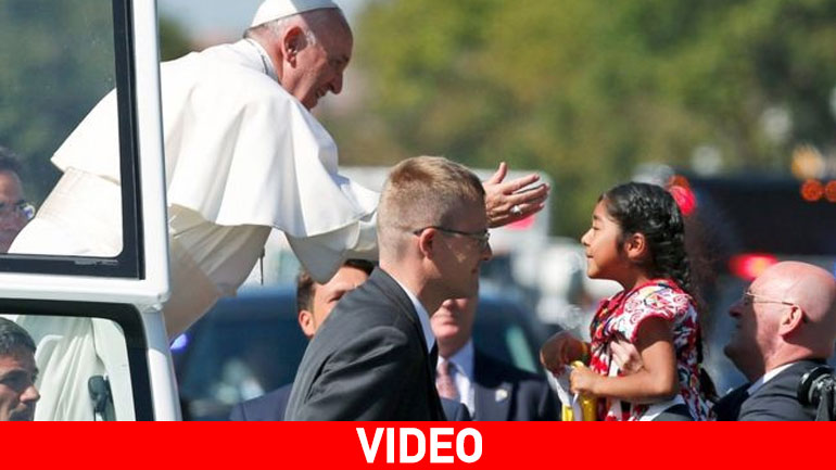 Ένα μικρό κορίτσι τρέχει στην αγκαλιά του Πάπα