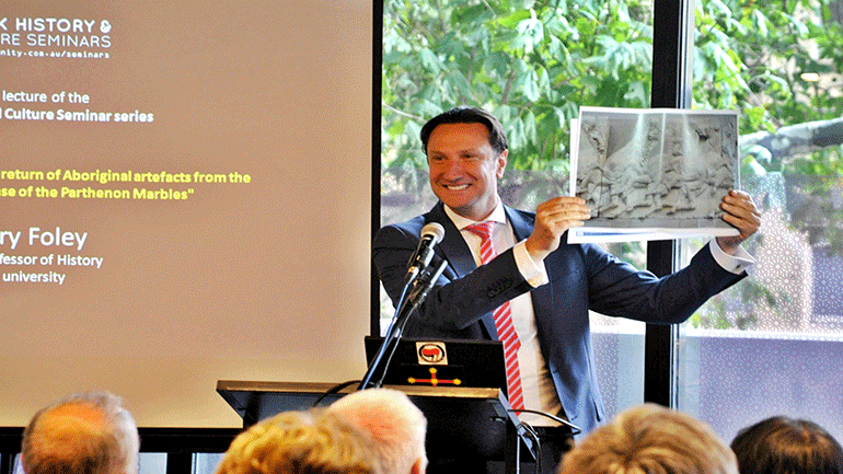 Ο πρόεδρος της Κοινότητας κ. Βασίλης Παπαστεργιάδης επιδεικνύει φωτογραφίες από το αντίγραφο των Μαρμάρων του Παρθενώνα που θα τοποθετηθεί στην πρόσοψη του νέου κοινοτικού κτιρίου