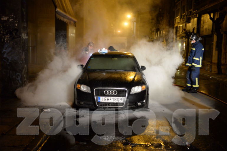 Άνδρες της Πυροσβεστικής σβήνουν φωτιά από σταθμευμένο αυτοκίνητο