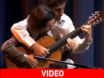 Δύο άτομα παίζουν ταυτόχρονα στην ίδια κιθάρα