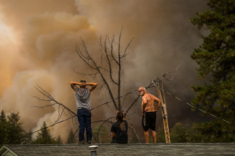 Κάτοικοι κοιτούν αποσβολωμένοι τις φλόγες