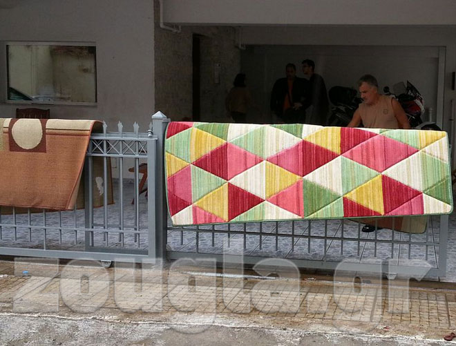 Κάτοικοι της Νίκαιας βγάζουν έξω από τα σπίτια τους τα βρεγμένα χαλιά